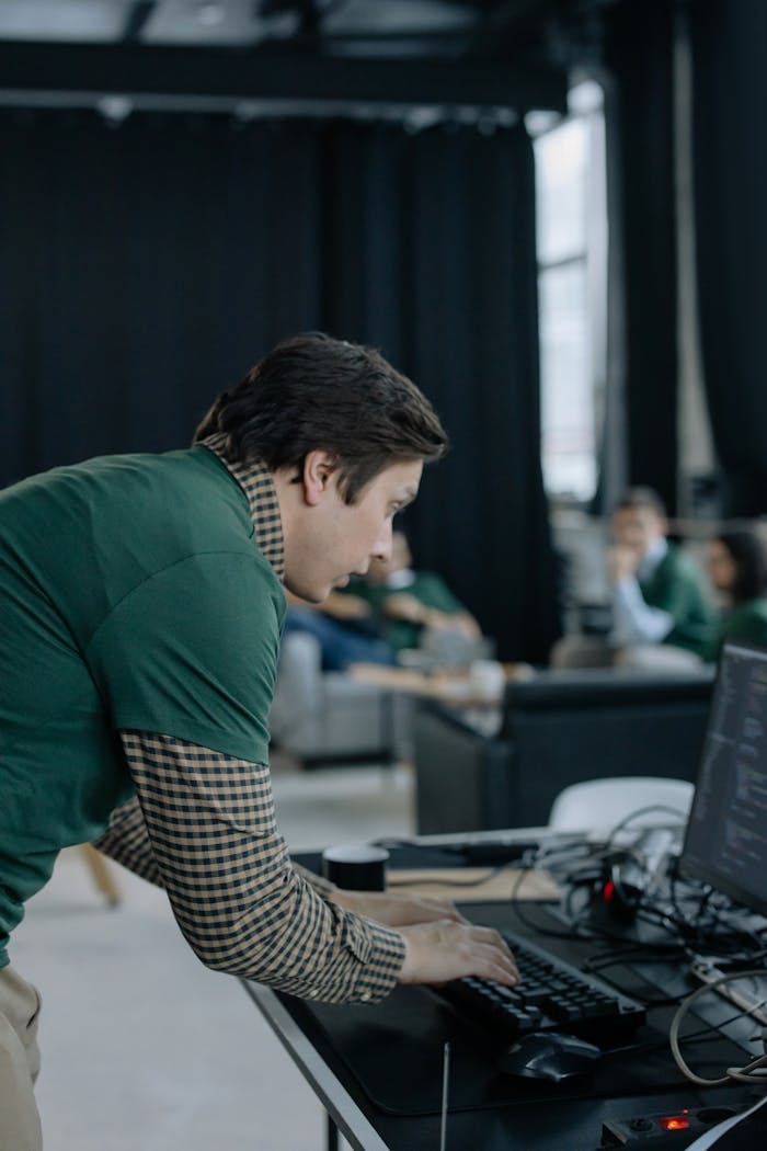 Focused man typing at a desk in a modern office setting with relaxed ambiance.